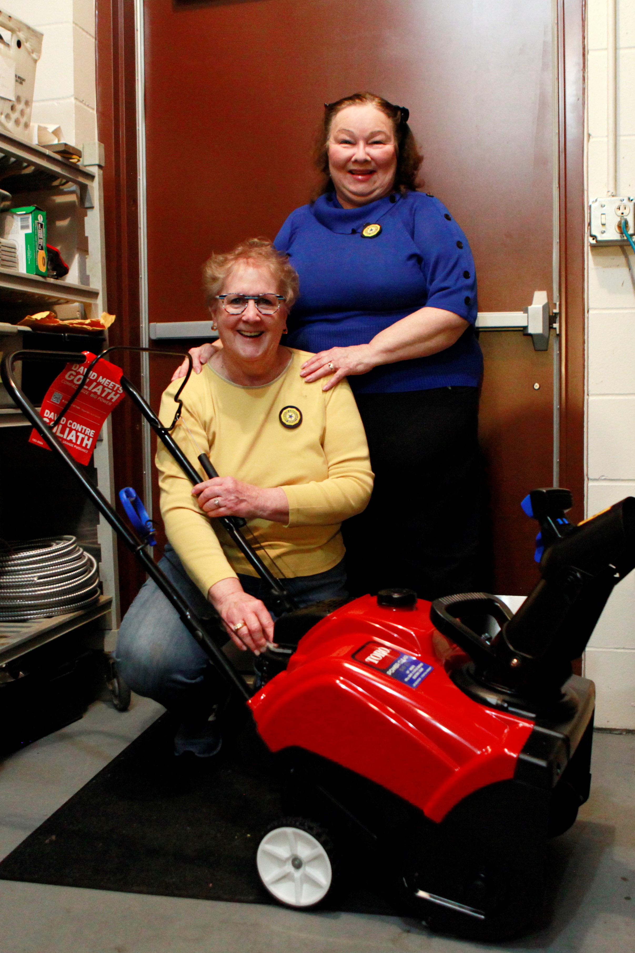 Photo of two women with snowblower. Auxiliary won new snowblower for the post.